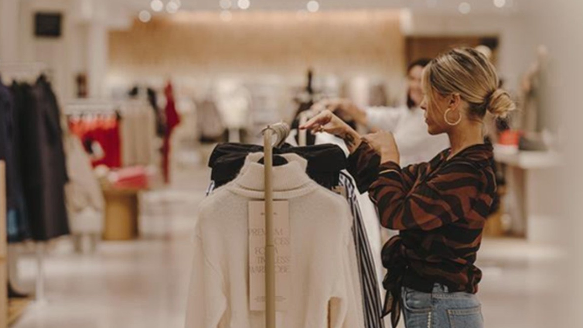 A shopper browsing knitwear inside a Mango store as the brand expands its Style Club loyalty programme across Europe