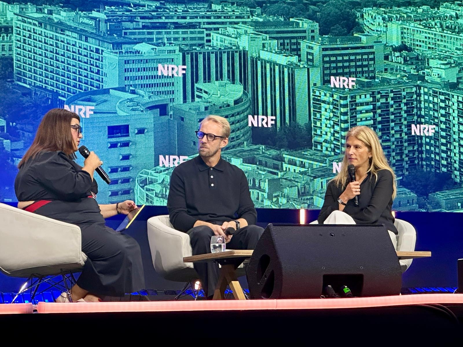 Panellists from ARKET and Aroma-Zone speaking with an interviewer on the NRF Retail's Big Show Europe stage in Paris