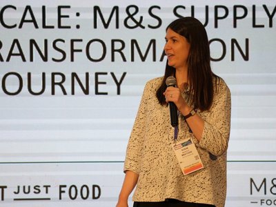 Susan Massicot, Head of Supply Chain at M&S Food, speaking on stage at NRF Europe in Paris in front of an M&S Food supply chain transformation slide.