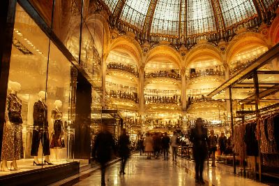 Grand Belle Époque atrium of a Parisian luxury department store with stained-glass dome and designer boutiques.
