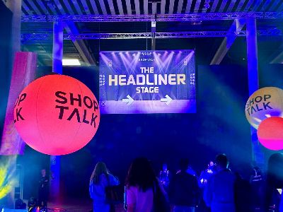 The Headliner Stage banner at Shoptalk Europe 2026, flanked by branded inflatable spheres and attendees gathering before the opening keynote.